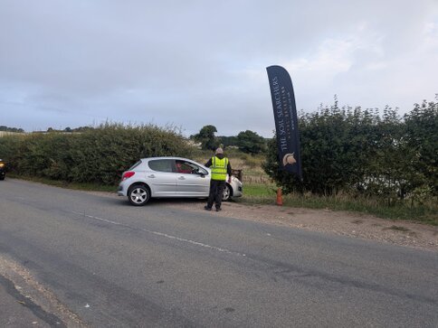 Detectorist and landowner talking at the edge of a field